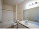 Well-lit bathroom featuring a tiled shower/tub combination, a toilet, and a vanity with a large mirror at 2600 Robert Trent Jones # 934, Orlando, FL 32835