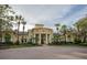 The building has a grand facade, with decorative columns, stucco walls, and lush tropical landscaping at 2600 Robert Trent Jones # 934, Orlando, FL 32835