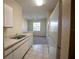 Compact kitchen featuring white appliances and cabinetry adjacent to a cozy living space with natural light at 2600 Robert Trent Jones # 934, Orlando, FL 32835