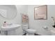 Clean powder room featuring a pedestal sink, a round mirror, neutral paint and classic fixtures at 2676 Gouda Dr, Apopka, FL 32703