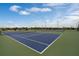 Community tennis courts with lighting in a manicured lawn on a sunny day at 2680 Gouda Dr, Apopka, FL 32703