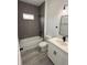 Modern bathroom featuring gray tile shower, white cabinets, and black hardware at 2703 Sw 162Nd Street Rd, Ocala, FL 34473