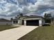 Beautiful one-story home showcasing a well-maintained yard, a black garage door, and stone accents at 2703 Sw 162Nd Street Rd, Ocala, FL 34473