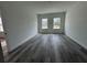 Well-lit living room with gray wood flooring and large windows overlooking the neighborhood at 2703 Sw 162Nd Street Rd, Ocala, FL 34473