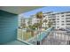 A view from a condo balcony showing the pool area and an ocean view condominium building under a clear sky at 2727 N Atlantic Ave # 2020, Daytona Beach, FL 32118