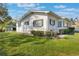 Charming single-story home featuring a lush lawn, mature landscaping, and a white brick exterior at 29 Jasmine Dr, Debary, FL 32713