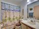 Well-lit bathroom featuring a single vanity and a shower with a beach themed curtain at 2956 S S Semoran Blvd # 1407, Orlando, FL 32822