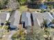 Aerial view of a home with a well-maintained landscape, surrounded by lush greenery and a serene pond at 300 Stonington Way, Deland, FL 32724