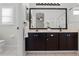 Well-lit bathroom featuring a double vanity with dark cabinets and a large mirror at 300 Stonington Way, Deland, FL 32724