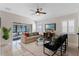 Living room with bright neutral colors, a ceiling fan, tile floors, and sliding doors to a screened in patio at 300 Stonington Way, Deland, FL 32724