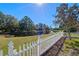 Scenic view of a pond from the backyard, with a white picket fence in the foreground at 300 Stonington Way, Deland, FL 32724