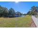 Peaceful pond view from the backyard, showcasing well-maintained landscaping and a clear blue sky at 300 Stonington Way, Deland, FL 32724