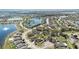 Aerial view of a neighborhood with single-Gathering homes surrounding a scenic lake with a fountain at 3223 Queen Alexandria Dr, Kissimmee, FL 34744