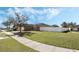 Well-manicured front yard with mature trees and side fencing at 3223 Queen Alexandria Dr, Kissimmee, FL 34744