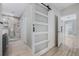 Hallway featuring a barn door leading to a full bath with marble tiling at 3223 Queen Alexandria Dr, Kissimmee, FL 34744