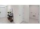 Hallway with gray-beige tiled floor, a white door on the left, and a console table with accessories and baskets at 33621 Seattle Slew Dr, Sorrento, FL 32776