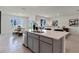 Modern kitchen with a quartz island bar top, stainless steel appliances, and an adjacent dining area at 33625 Seattle Slew Dr, Sorrento, FL 32776