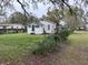 Exterior view shows home siding, windows and lush yard with chain link fence at 3420 Avenue R Nw, Winter Haven, FL 33881