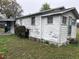 A view of the side of the home with worn siding and landscaping at 3420 Avenue R Nw, Winter Haven, FL 33881