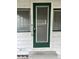 A close up shot of the front door with green trim and two windows on either side at 3420 Avenue R Nw, Winter Haven, FL 33881