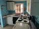 Image of the kitchen with blue walls, a vintage range, double basin sink, and white cabinets at 3420 Avenue R Nw, Winter Haven, FL 33881