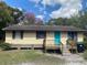 Charming single-story home featuring a bright blue front door and a cozy wooden porch at 4235 Lake Lockhart Dr, Orlando, FL 32810