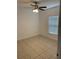 This bedroom is bright and includes tile flooring, a ceiling fan, and a window at 424 Crabtree Ave, Orlando, FL 32835