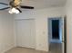 This bedroom features a ceiling fan, tile flooring, and a double door closet for storage at 424 Crabtree Ave, Orlando, FL 32835