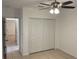 A bright bedroom features a ceiling fan, closet with double doors, and tile flooring at 424 Crabtree Ave, Orlando, FL 32835