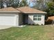 Home featuring a well kept front yard with a flower pot near the front entrance and an attached garage at 424 Crabtree Ave, Orlando, FL 32835