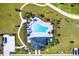 Aerial view of a community pool featuring lush landscaping, deck chairs, and a blue swimming pool at 4485 Davos Dr, Clermont, FL 34711