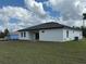 The back exterior of a home has a backyard with large windows and sliding glass doors at 4875 Sw 159Th Lane Rd, Ocala, FL 34473