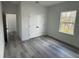 A bright bedroom features a closet, a window with natural light, and gray wood-look flooring at 4875 Sw 159Th Lane Rd, Ocala, FL 34473