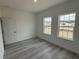 Bright bedroom with wood-look flooring, neutral walls, and two large windows at 4875 Sw 159Th Lane Rd, Ocala, FL 34473