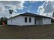 A modern-style home boasts a sleek, dark roof, white stucco walls, complemented by a pristine, sprawling lawn at 4875 Sw 159Th Lane Rd, Ocala, FL 34473