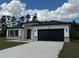 A charming home showcases a dark-colored roof, and a black garage door at 4875 Sw 159Th Lane Rd, Ocala, FL 34473