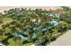 Aerial view of resort community including a pool, lazy river, tennis courts, and lush landscaping at 5384 Oakbourne Ave, Davenport, FL 33837