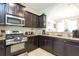 Well-equipped kitchen featuring stainless steel appliances, dark wood cabinetry, and granite countertops at 5384 Oakbourne Ave, Davenport, FL 33837