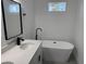 Bright bathroom boasts a modern free-standing tub, sink vanity, quartz countertop, and matte black fixtures at 616 Marion Oaks Ln, Ocala, FL 34473