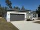 Single Gathering home with a gray garage door, stone accents, and manicured landscaping at 616 Marion Oaks Ln, Ocala, FL 34473