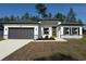 Charming single-story home featuring a gray garage door, bright white stucco, and simple landscaping at 616 Marion Oaks Ln, Ocala, FL 34473