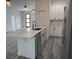 Bright kitchen features gray wood-look floors, white cabinets, and a quartz countertop island at 616 Marion Oaks Ln, Ocala, FL 34473