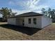 A home's rear exterior featuring a covered lanai, well kept yard and a dark roof at 616 Marion Oaks Ln, Ocala, FL 34473