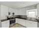 Well-lit kitchen features modern stainless steel appliances, white cabinets, and contrasting dark countertops at 662 Sausalito Blvd, Casselberry, FL 32707