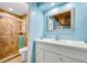 Bathroom featuring a tiled shower, toilet, and vanity with large mirror and a wood paneled ceiling at 721 Glenridge Way, Winter Park, FL 32789