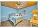 Bright bedroom featuring a tongue and groove wood ceiling, blue walls, and a comfortable queen-sized bed at 721 Glenridge Way, Winter Park, FL 32789