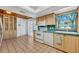 Bright kitchen featuring tile floors, white appliances, and light wood cabinetry at 721 Glenridge Way, Winter Park, FL 32789