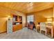 Home office featuring wood paneled walls, built-in shelving, a desk, and natural light from the window at 721 Glenridge Way, Winter Park, FL 32789