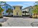 Charming yellow home featuring a cozy seating area with a tranquil ambiance and lush landscaping at 8005 Flip Flop Way, Kissimmee, FL 34747