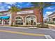 Exterior view of Flower Cafe Bakery, Coffee, and Vibes, with outdoor seating and palm trees at 8005 Flip Flop Way, Kissimmee, FL 34747